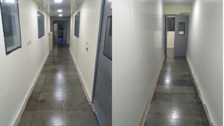 Production corridor at the Sansarpur Terrace pharma plant with inspection viewing windows into manufacturing rooms and flush doors